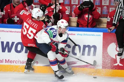 Ludvig Hoff of Norway, right, fights for a puck with Romain Loeffel of Switzerland during the group B match between Norway and Switzerland at the ice hockey world championship in Riga, Latvia, Sunday, May 14, 2023. (AP Photo/Roman Koksarov)