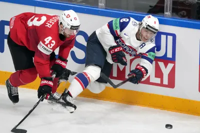 Mathias Trettenes of Norway, right, fights for a puck with Andrea Glauser of Switzerland during the group B match between Norway and Switzerland at the ice hockey world championship in Riga, Latvia, Sunday, May 14, 2023. (AP Photo/Roman Koksarov)