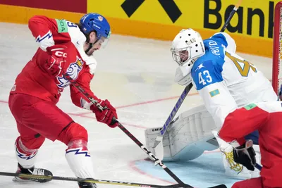 Daniel Vozelinek of Czech Republic, left, fights for a puck with goalie Andrey Shutov of Kazakhstan during the group B match between Czech Republic and Kazakhstan at the ice hockey world championship in Riga, Latvia, Sunday, May 14, 2023. (AP Photo/Roman Koksarov)