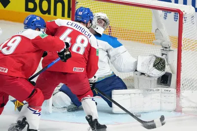 Jiri Cernoch of Czech Republic, centre, fights for a puck with goalie Andrey Shutov of Kazakhstan during the group B match between Czech Republic and Kazakhstan at the ice hockey world championship in Riga, Latvia, Sunday, May 14, 2023. (AP Photo/Roman Koksarov)
