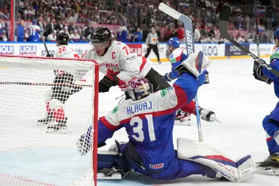 Goalie Samuel Hlavaj of Slovakia, right, fights for a puck with Tyler Toffoli of Canada during the group B match between Slovakia and Canada at the ice hockey world championship in Riga, Latvia, Monday, May 15, 2023. (AP Photo/Roman Koksarov)