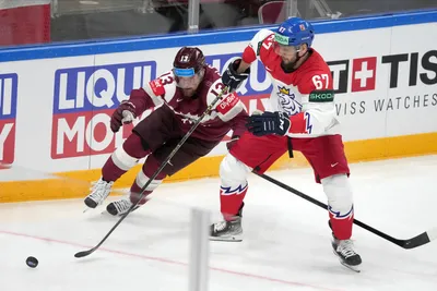 Rihards Bukarts of Latvia, left, fights for a puck with Jakub Zboril of Czech Republic during the group B match between Latvia and Czech Republic at the ice hockey world championship in Riga, Latvia, Monday, May 15, 2023. (AP Photo/Roman Koksarov)