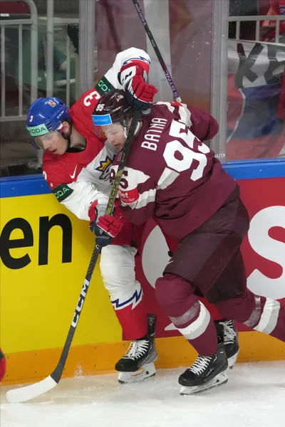 Oskars Batna of Latvia, right, fights for a puck with Ronald Knot of Czech Republic during the group B match between Latvia and Czech Republic at the ice hockey world championship in Riga, Latvia, Monday, May 15, 2023. (AP Photo/Roman Koksarov)