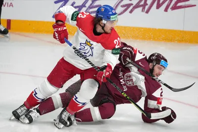 Uvis Balinskis of Latvia, right, fights for a puck with Lukas Sedlak of Czech Republic during the group B match between Latvia and Czech Republic at the ice hockey world championship in Riga, Latvia, Monday, May 15, 2023. (AP Photo/Roman Koksarov)