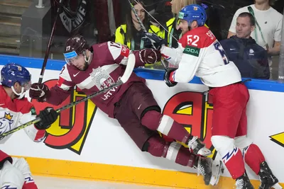 Martins Dzierkals of Latvia, left, fights for a puck with Michael Spacek of Czech Republic during the group B match between Latvia and Czech Republic at the ice hockey world championship in Riga, Latvia, Monday, May 15, 2023. (AP Photo/Roman Koksarov)