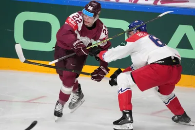 Toms Andersons of Latvia, left, fights for a puck with Michal Kempny of Czech Republic during the group B match between Latvia and Czech Republic at the ice hockey world championship in Riga, Latvia, Monday, May 15, 2023. (AP Photo/Roman Koksarov)