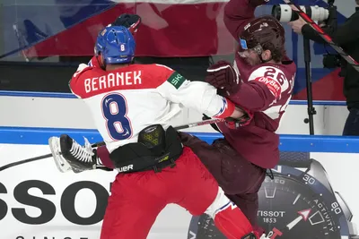 Uvis Balinskis of Latvia, right, fights for a puck with Ondrej Beranek of Czech Republic during the group B match between Latvia and Czech Republic at the ice hockey world championship in Riga, Latvia, Monday, May 15, 2023. (AP Photo/Roman Koksarov)