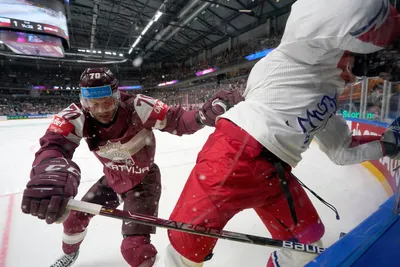 Miks Indrasis of Latvia, left, fights for a puck with Jiri Cernoch of Czech Republic during the group B match between Latvia and Czech Republic at the ice hockey world championship in Riga, Latvia, Monday, May 15, 2023. (AP Photo/Roman Koksarov)