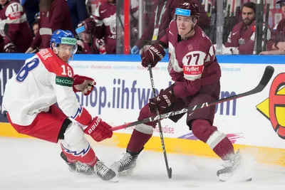 Kristaps Zile of Latvia, right, fights for a puck with Dominik Kubalik of Czech Republic during the group B match between Latvia and Czech Republic at the ice hockey world championship in Riga, Latvia, Monday, May 15, 2023. (AP Photo/Roman Koksarov)