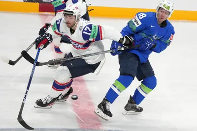 Ken Ograjensek of Slovenia, right, fights for a puck with Eirik Salsten of Norway during the group B match between Slovenia and Norway at the ice hockey world championship in Riga, Latvia, Tuesday, May 16, 2023. (AP Photo/Roman Koksarov)