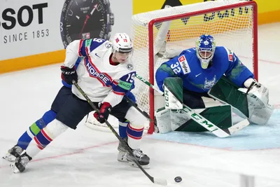 Goalie Gasper Kroselj of Slovenia, right, fights for a puck with Havard Salsten of Norway during the group B match between Slovenia and Norway at the ice hockey world championship in Riga, Latvia, Tuesday, May 16, 2023. (AP Photo/Roman Koksarov)
