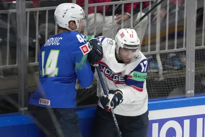 Aleksandar Magovac of Slovenia, left, fights for a puck with Eirik Salsten of Norway during the group B match between Slovenia and Norway at the ice hockey world championship in Riga, Latvia, Tuesday, May 16, 2023. (AP Photo/Roman Koksarov)
