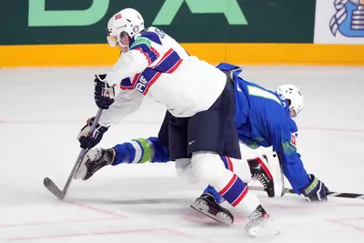 Jan Drozd of Slovenia, right, fights for a puck with Johannes Johannesen of Norway during the group B match between Slovenia and Norway at the ice hockey world championship in Riga, Latvia, Tuesday, May 16, 2023. (AP Photo/Roman Koksarov)
