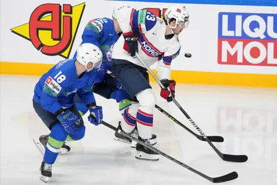 Ken Ograjensek, left, Nik Simsic, centre of Slovenia, fight for a puck with Sondre Olden of Norway during the group B match between Slovenia and Norway at the ice hockey world championship in Riga, Latvia, Tuesday, May 16, 2023. (AP Photo/Roman Koksarov)