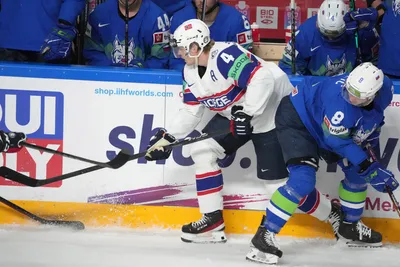 Ziga Jeglic of Slovenia, right, fights for a puck with Johannes Johannesen of Norway during the group B match between Slovenia and Norway at the ice hockey world championship in Riga, Latvia, Tuesday, May 16, 2023. (AP Photo/Roman Koksarov)