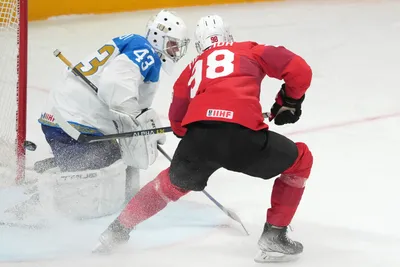 Marco Miranda of Switzerland, right, fights for a puck with Andrey Shutov of Kazakhstan during the group B match between Switzerland and Kazakhstan at the ice hockey world championship in Riga, Latvia, Tuesday, May 16, 2023. (AP Photo/Roman Koksarov)