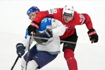 Fabrice Herzog of Switzerland, right, fights for a puck with Artyom Korolyov of Kazakhstan during the group B match between Switzerland and Kazakhstan at the ice hockey world championship in Riga, Latvia, Tuesday, May 16, 2023. (AP Photo/Roman Koksarov)