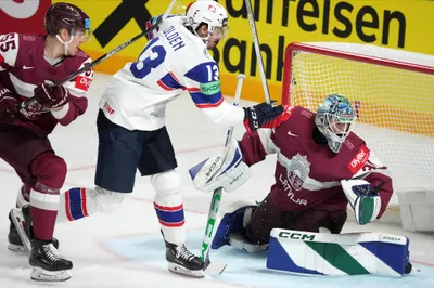 Latvia's goalie Arturs Silovs, right, and Roberts Mamcics, left, fight for a puck with Sondre Olden of Norway during the group B match between Latvia and Norway at the ice hockey world championship in Riga, Latvia, Wednesday, May 17, 2023. (AP Photo/Roman Koksarov)