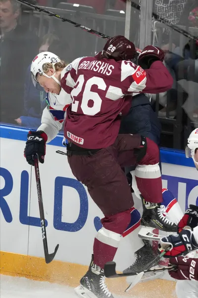 Uvis Balinskis of Latvia, front, fights for a puck with Thomas Berg-Paulsen of Norway during the group B match between Latvia and Norway at the ice hockey world championship in Riga, Latvia, Wednesday, May 17, 2023. (AP Photo/Roman Koksarov)