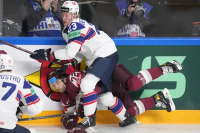 Janis Jaks of Latvia fights for a puck with Thomas Berg-Paulsen of Norway, front, during the group B match between Latvia and Norway at the ice hockey world championship in Riga, Latvia, Wednesday, May 17, 2023. (AP Photo/Roman Koksarov)