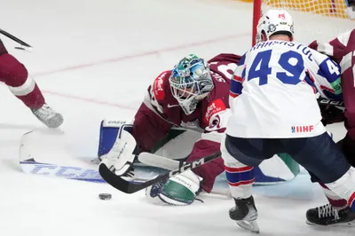 Goalie Arturs Silovs of Latvia, centre, fights for a puck with Christian Kaasastul of Norway during the group B match between Latvia and Norway at the ice hockey world championship in Riga, Latvia, Wednesday, May 17, 2023. (AP Photo/Roman Koksarov)