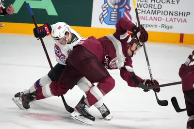 Andris Dzerins of Latvia, right, fights for a puck with Mathias Trettenes of Norway during the group B match between Latvia and Norway at the ice hockey world championship in Riga, Latvia, Wednesday, May 17, 2023. (AP Photo/Roman Koksarov)