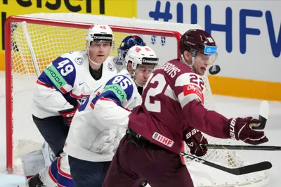 Toms Andersons of Latvia, right, fights for a puck with Michael Haga, centre, and Christian Kaasastul, left, of Norway during the group B match between Latvia and Norway at the ice hockey world championship in Riga, Latvia, Wednesday, May 17, 2023. (AP Photo/Roman Koksarov)