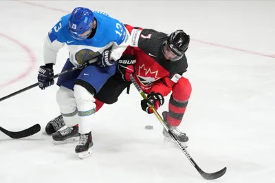 Pierre-Olivier Joseph of Canada, right, fights for a puck with Dinmukhamed Kaiyrzhan of Kazakhstan during the group B match between Canada and Kazakhstan at the ice hockey world championship in Riga, Latvia, Wednesday, May 17, 2023. (AP Photo/Roman Koksarov)