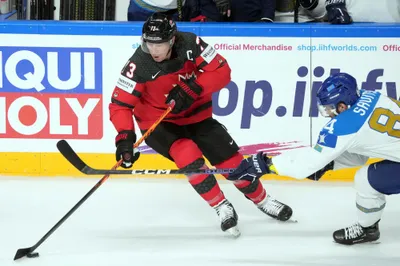 Tyler Toffoli of Canada, left, fights for a puck with Kirill Savitski of Kazakhstan during the group B match between Canada and Kazakhstan at the ice hockey world championship in Riga, Latvia, Wednesday, May 17, 2023. (AP Photo/Roman Koksarov)