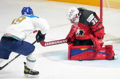 Goalie Joel Hofer of Canada, right, fights for a puck with Mikhail Rakhmanov of Kazakhstan during the group B match between Canada and Kazakhstan at the ice hockey world championship in Riga, Latvia, Wednesday, May 17, 2023. (AP Photo/Roman Koksarov)