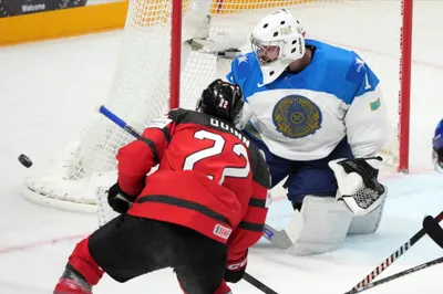 Jack Quinn of Canada, left, fights for a puck with goalie Nikita Boyarkin of Kazakhstan during the group B match between Canada and Kazakhstan at the ice hockey world championship in Riga, Latvia, Wednesday, May 17, 2023. (AP Photo/Roman Koksarov)