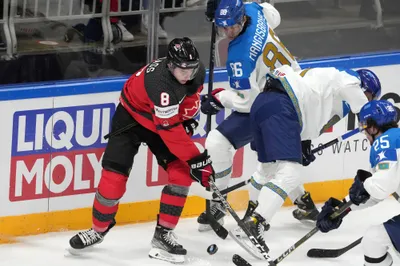 Cody Glass of Canada, left, fights for a puck with Abay Mangisbayev of Kazakhstan during the group B match between Canada and Kazakhstan at the ice hockey world championship in Riga, Latvia, Wednesday, May 17, 2023. (AP Photo/Roman Koksarov)