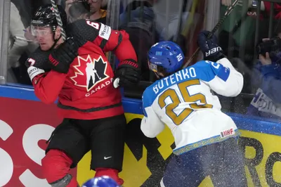 Lawson Crouse of Canada, left, fights for a puck with Danil Butenko of Kazakhstan during the group B match between Canada and Kazakhstan at the ice hockey world championship in Riga, Latvia, Wednesday, May 17, 2023. (AP Photo/Roman Koksarov)