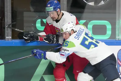 David Tomasek of Czech Republic, left, fights for a puck with Robert Sabolic of Slovenia during the group B match between Czech Republic and Slovenia at the ice hockey world championship in Riga, Latvia, Thursday, May 18, 2023. (AP Photo/Roman Koksarov)