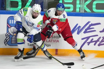 Ondrej Beranek of Czech Republic, right, fights for a puck with Nik Simsic of Slovenia during the group B match between Czech Republic and Slovenia at the ice hockey world championship in Riga, Latvia, Thursday, May 18, 2023. (AP Photo/Roman Koksarov)