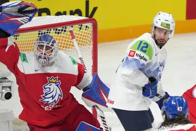 Goalie Karel Vejmelka of Czech Republic, left, fights for a puck with Nik Simsic of Slovenia during the group B match between Czech Republic and Slovenia at the ice hockey world championship in Riga, Latvia, Thursday, May 18, 2023. (AP Photo/Roman Koksarov)