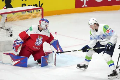 Goalie Karel Vejmelka of Czech Republic, left, fights for a puck with Jan Drozd of Slovenia during the group B match between Czech Republic and Slovenia at the ice hockey world championship in Riga, Latvia, Thursday, May 18, 2023. (AP Photo/Roman Koksarov)