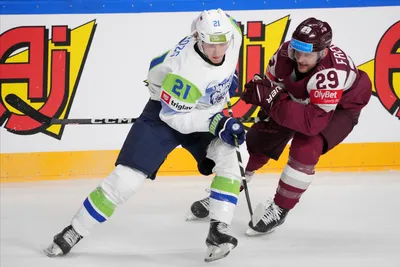 Ralfs Freibergs of Latvia, right, fights for a puck with Jan Drozd of Slovenia during the group B match between Latvia and Slovenia at the ice hockey world championship in Riga, Latvia, Friday, May 19, 2023. (AP Photo/Roman Koksarov)