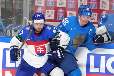 Mario Lunter of Slovakia, left, fights for a puck with Roman Starchenko of Kazakhstan during the group B match between Slovakia and Kazakhstan at the ice hockey world championship in Riga, Latvia, Friday, May 19, 2023. (AP Photo/Roman Koksarov)