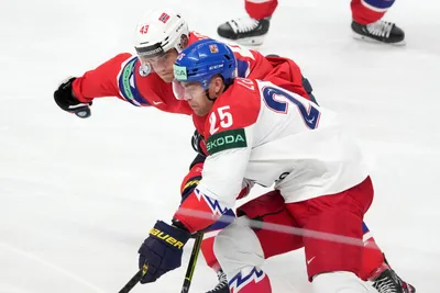 Max Krogdahl of Norway, back, fights for a puck with Radan Lenc of Czech Republic during the group B match between Norway and Czech Republic at the ice hockey world championship in Riga, Latvia, Saturday, May 20, 2023. (AP Photo/Roman Koksarov)