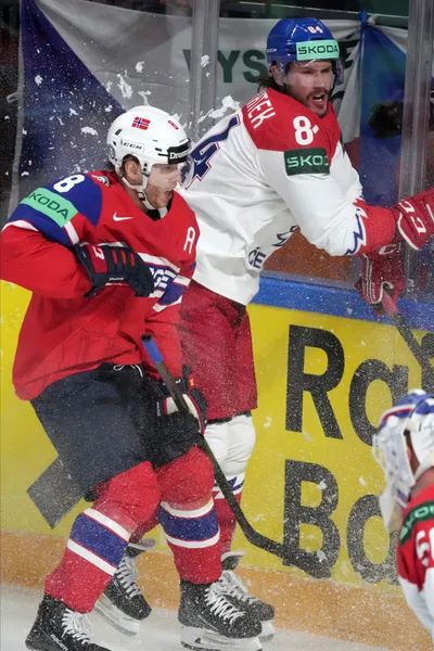 Mathias Trettenes of Norway, left, fights for a puck with Tomas Kundratekof Czech Republic during the group B match between Norway and Czech Republic at the ice hockey world championship in Riga, Latvia, Saturday, May 20, 2023. (AP Photo/Roman Koksarov)