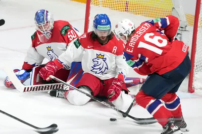 Ole Einar Andersen of Norway, right, fights for a puck with Michal Jordan, centre, and goalie Jan Kostalek of Czech Republic during the group B match between Norway and Czech Republic at the ice hockey world championship in Riga, Latvia, Saturday, May 20, 2023. (AP Photo/Roman Koksarov)