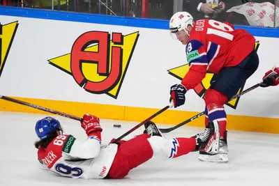 Thomas Olsen of Norway, right, fights for a puck with Daniel Vozelinek of Czech Republic during the group B match between Norway and Czech Republic at the ice hockey world championship in Riga, Latvia, Saturday, May 20, 2023. (AP Photo/Roman Koksarov)