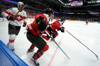 Nino Niederreiter of Switzerland, left, fights for a puck with Adam Fantilli, centre, and Cody Glass of Canada during the group B match between Switzerland and Canada at the ice hockey world championship in Riga, Latvia, Saturday, May 20, 2023. (AP Photo/Roman Koksarov)