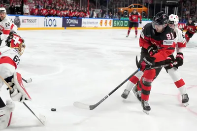 Goalie Leonardo Genoni of Switzerland, left, fights for a puck with Adam Fantilli of Canada during the group B match between Switzerland and Canada at the ice hockey world championship in Riga, Latvia, Saturday, May 20, 2023. (AP Photo/Roman Koksarov)