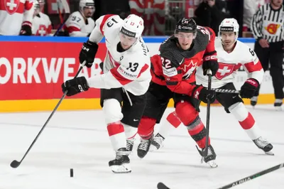 Nico Hischier of Switzerland, left, fights for a puck with Jack Quinn of Canada during the group B match between Switzerland and Canada at the ice hockey world championship in Riga, Latvia, Saturday, May 20, 2023. (AP Photo/Roman Koksarov)