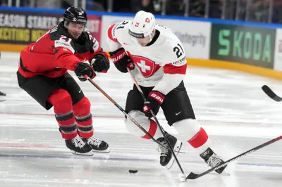 Kevin Fiala of Switzerland, right, fights for a puck with Scott Laughton of Canada during the group B match between Switzerland and Canada at the ice hockey world championship in Riga, Latvia, Saturday, May 20, 2023. (AP Photo/Roman Koksarov)