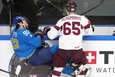 Arvils Bergmanis of Latvia, right, fights for a puck with Dmitri Grents of Kazakhstan during the group B match between Kazakhstan and Latvia at the ice hockey world championship in Riga, Latvia, Saturday, May 20, 2023. (AP Photo/Roman Koksarov)