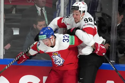 Jan Kostalek of Czech Republic, right, fights for a puck with Marco Miranda of Switzerland during the group B match between Czech Republic and Switzerland at the ice hockey world championship in Riga, Latvia, Sunday, May 21, 2023. (AP Photo/Roman Koksarov)
