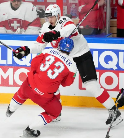 Jan Kostalek of Czech Republic, right, fights for a puck with Christian Marti of Switzerland during the group B match between Czech Republic and Switzerland at the ice hockey world championship in Riga, Latvia, Sunday, May 21, 2023. (AP Photo/Roman Koksarov)